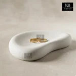 Minimalist concrete jewellery display tray styled with rings, earrings and delicate accessories