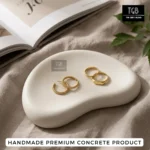 Bean shaped concrete tray used as a flat lay photography prop for jewellery and small accessories