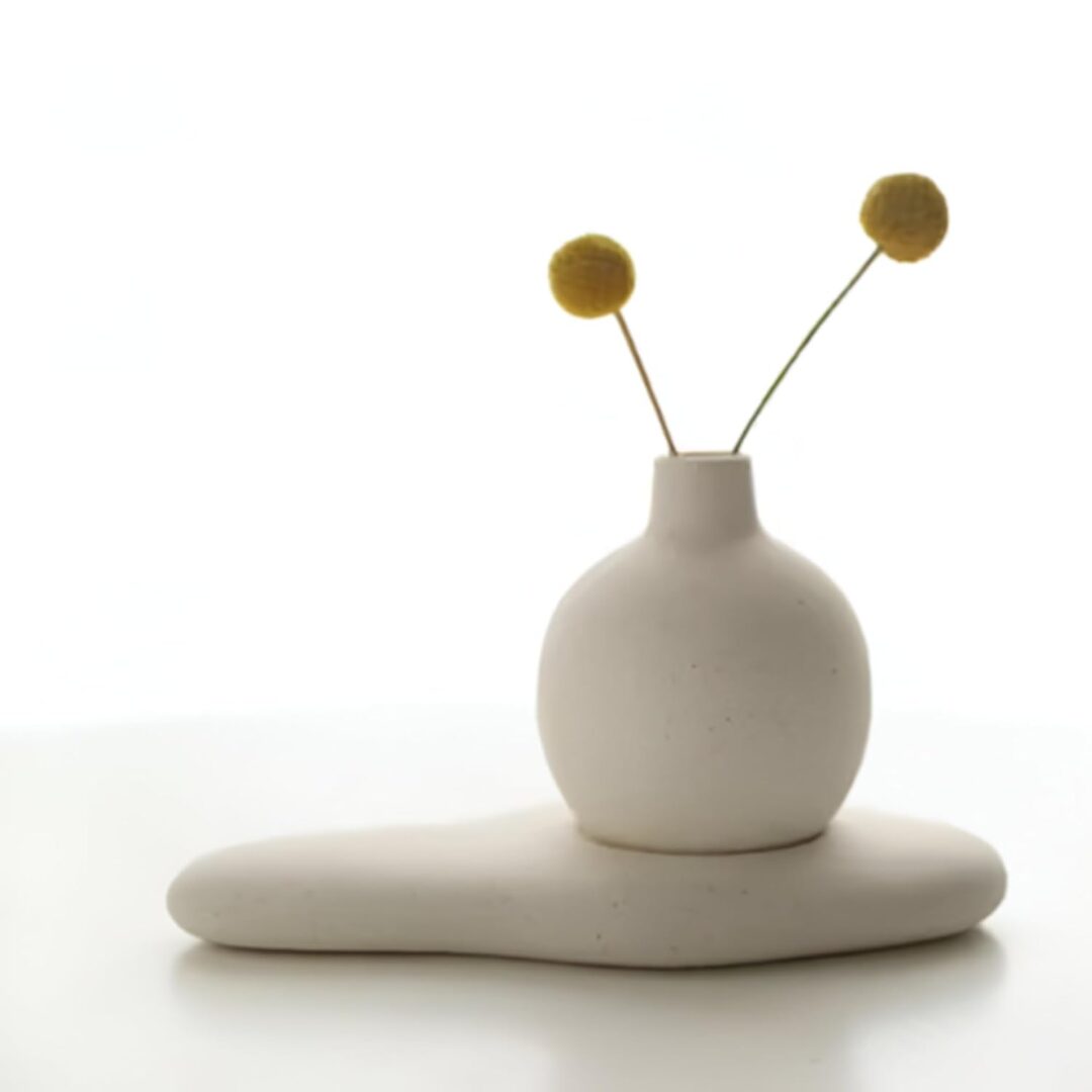 Handcrafted white concrete round bud vase on a coffee table
