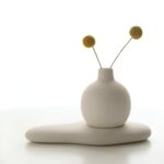 Handcrafted white concrete round bud vase on a coffee table